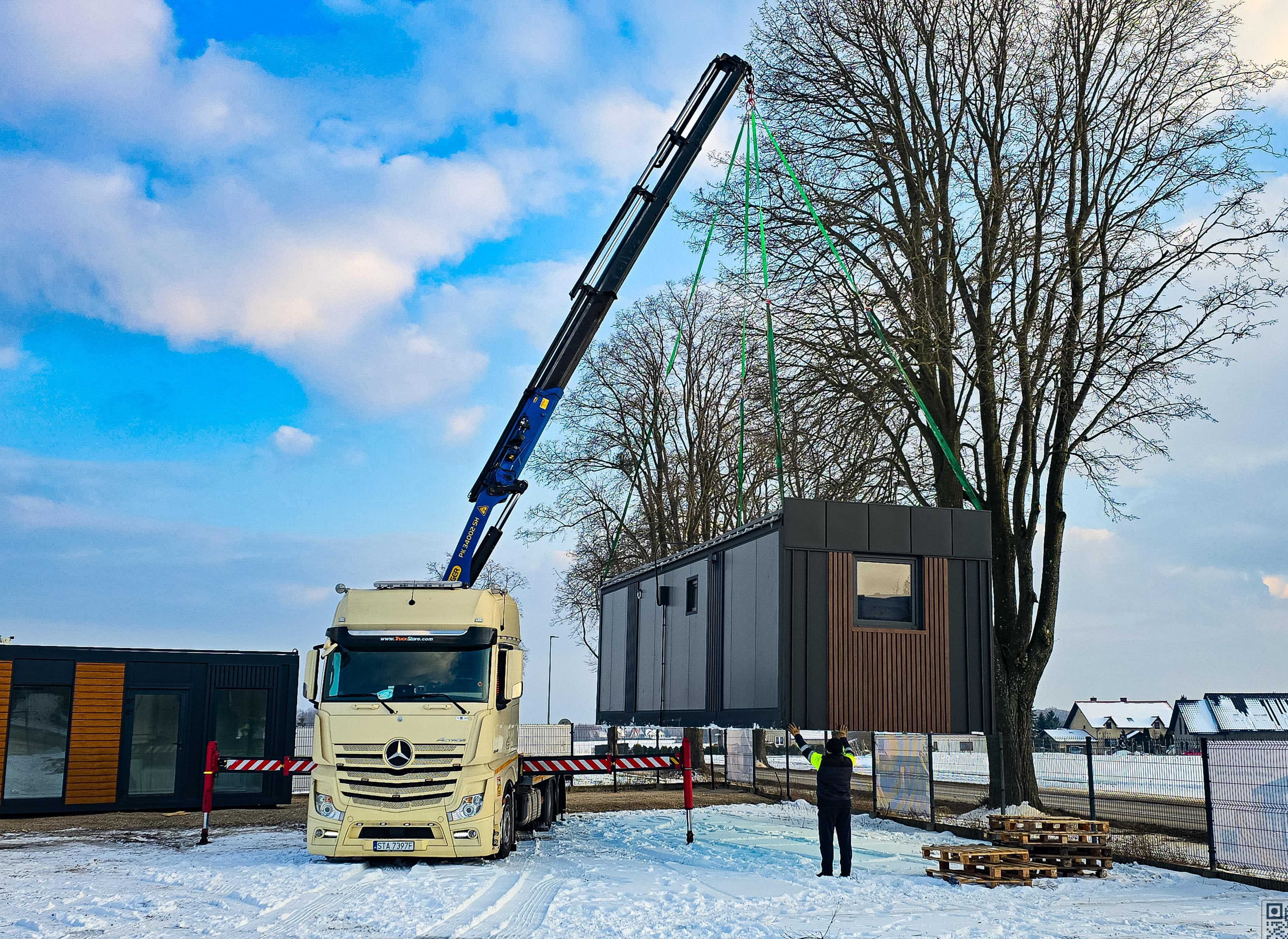 Container being unloaded with crane in snow